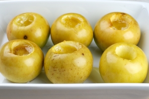 Выпекать в разогретой до 180 °С духовке 10-20 минут, пока не начнёт лопаться кожица яблок. Подавать с изюмом и грецкими орехами.