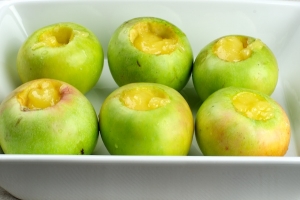 Выложить яблоки на противень или в форму и добавить по 2 чайные ложки мёда.